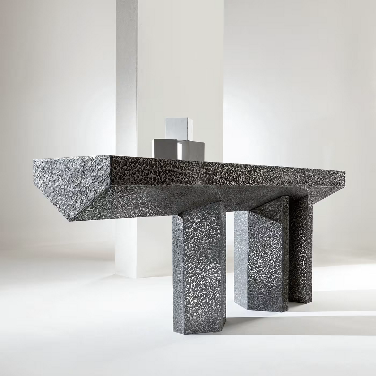 Imperfetto asymmetrical three-legged liquid metal tin console
